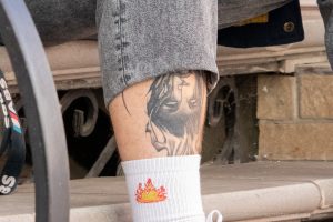 Фото татуировки: черно-белый портрет женщины на руке мужчины, выполненный в реалистичном стиле. Детализированная проработка черт лица и волос.