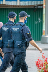 Фото тату: сотрудник Национальной гвардии Украины в движении с черной татуировкой-надписью на предплечье.