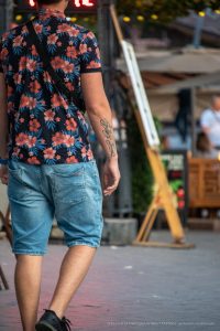 Фото татуировки на руке мужчины, представляющей собой надпись, выполненную в стиле каллиграфии. Черные чернила, изящный шрифт.