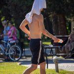 Фотография мужчины с татуировкой надписью на руке, занимающегося спортом на открытом воздухе. Надпись выполнена черными чернилами, шрифт каллиграфический.