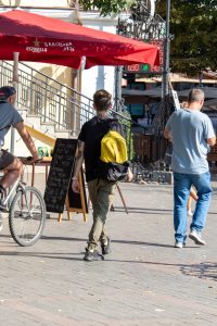Фото татуировки на плече мужчины, представляющей собой абстрактный рисунок в черных тонах. Минималистичный стиль, лаконичное исполнение.