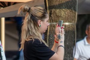Фотография женщины с татуировками на руке, делающей селфи на телефон. Видна татуировка в виде звезды и растительного орнамента.