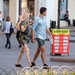 Фото тату: пара, девушка с татуировкой портрета на ноге и цветочных узоров на руке, и молодой человек. Стильный образ с татуировками.