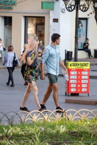 Фото тату: пара, девушка с татуировкой портрета на ноге и цветочных узоров на руке, и молодой человек. Стильный образ с татуировками.