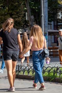 Фото тату: черная татуировка птицы на руке девушки. Изящный рисунок татуировки выполнен в минималистичном стиле.