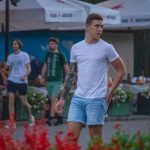 Фотография мужчины с татуировкой на руке, держащего сигарету. Татуировка выполнена в темных тонах и занимает большую часть предплечья.