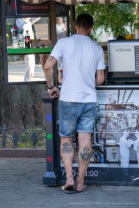 Фото тату на спине мужчины: абстрактный рисунок в черно-серых тонах. Эскиз татуировки состоит из геометрических фигур и линий.