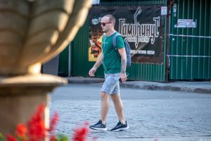 Фото мужчины с татуировкой на руке в готическом стиле. Детализированный рисунок с аркой и деревьями, выполненный в черно-серых тонах. Пример стильного рисунка татуировки.