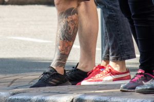 Крупный план фото татуировки на икре с изображением тигра и цветов лотоса в японском стиле. Детализированный рисунок, яркие цвета.