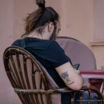 Фотография мужчины с татуировкой короны и имени на руке, выполненной черными чернилами. Видны римские цифры под именем.