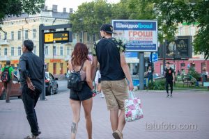 Фото тату на икре: детализированный рисунок, частично скрытый одеждой. Изображение татуировки с темными тонами и сложным узором.
