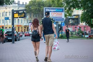 Фото тату на икре: детализированный рисунок, частично скрытый одеждой. Изображение татуировки с темными тонами и сложным узором.