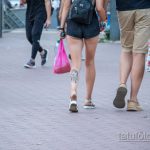 Фото тату на икре: карп кои с цветами, выполненный в черно-белой гамме. Детализированный рисунок, плавные линии, динамичная композиция.