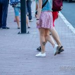 Фотография татуировки Дэдпула на ноге девушки. Черно-белый рисунок в стиле комиксов, изображающий персонажа в динамичной позе.