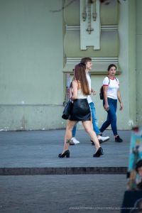 Фото тату: черная татуировка пальмы на икре девушки, выполненная в минималистичном стиле. Стильный образ в городской среде.