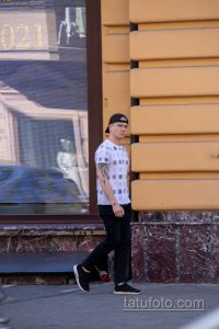 Фото татуировки в виде рукава на руке мужчины. Детализированный рисунок с черепами, узорами и графическими элементами. Идеи для тату.