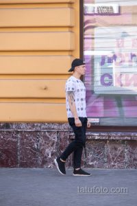 Фото татуировки в виде рукава на руке мужчины. Детализированный рисунок с черепами, узорами и графическими элементами. Идеи для тату.