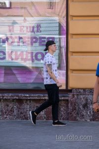 Фото татуировки в виде рукава на руке мужчины. Детализированный рисунок с черепами, узорами и графическими элементами. Идеи для тату.