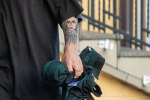 Крупный план татуировки с портретом девушки на предплечье мужчины, выполненной в реалистичном стиле.