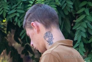 Крупный план фотографии татуировки розы на шее мужчины. Видны детализированные лепестки и тени, создающие реалистичный эффект.