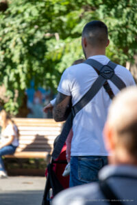 Фото тату на предплечье мужчины, выполненное в черных тонах с элементами красного. Детализированный рисунок с абстрактными формами и брызгами краски.