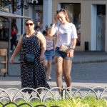 Фотография девушки, идущей по улице с видимой татуировкой на бедре. Татуировка выполнена в черно-белых тонах и изображает цветы и тигра.