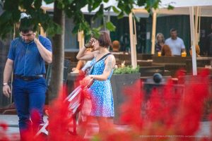 Фото тату на плече девушки: яркий цветочный рисунок с использованием синих, белых и зеленых оттенков. Эскиз татуировки выглядит свежо и стильно.