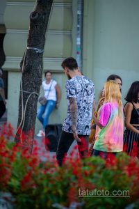 Фото тату: большая татуировка в стиле аниме на руке мужчины. Изображены персонажи и элементы японской культуры.