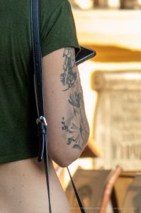 Фото тату на предплечье: детальный рисунок букета из цветов и листьев, выполненный в технике тонких линий. Идеально для вдохновения и поиска идей.