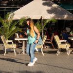 Фото татуировки на плече женщины. Виден фрагмент рисунка, предположительно, в стиле графика или орнамента. Черно-серый рисунок на загорелой коже.