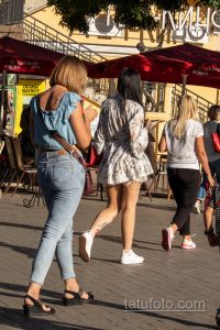 Фотография двух женщин, прогуливающихся по городской улице в летней одежде. Изображение демонстрирует модные тенденции и повседневный стиль.