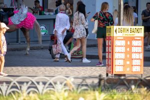 Фото татуировок на ногах женщины, сделанное в городской среде. Видны детализированные рисунки в стиле традишнл.