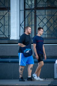 Фото татуировок на руках мужчины: татуировки на плече и предплечье, темные цвета, абстрактные рисунки, современный стиль.