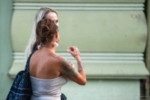 Фото тату на плече женщины. Красивый рисунок с цветами и листьями, выполненный в реалистичном стиле.