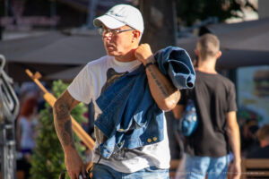 Фото тату на руке мужчины: рукав с рисунками тигра, надписью и другими элементами. Мужчина в повседневной одежде, демонстрирующий татуировки.