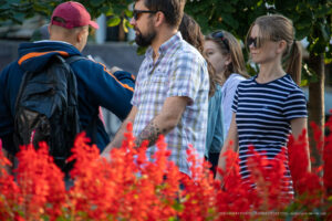 Фото мужчины с татуировкой на предплечье: сложный геометрический рисунок в красно-черной гамме. Стильный образ и детализированный эскиз тату.