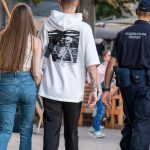 Фотография мужчины с татуировкой скелета на спине. Татуировка выполнена в чёрно-белой гамме и изображает скелет, держащий в руках оружие.