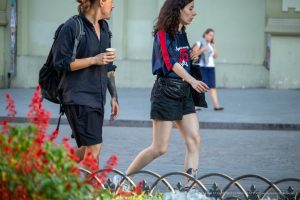 Фото тату небольшого цветка и геометрического узора на лодыжке девушки. Черно-белый рисунок в минималистичном стиле. Идеи для женских тату.