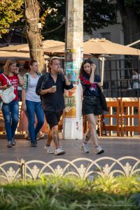 Фото пары, гуляющей по улице. У мужчины татуировка на руке, у девушки - татуировка на лодыжке. Уличный стиль, модные образы.