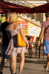Фото тату: маленькая черная татуировка в виде веточки с листьями на внутренней стороне руки девушки. Минималистичный рисунок.