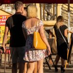 Фото тату на руке женщины, изображающее небольшой темный рисунок, напоминающий ветку с листьями. Татуировка выполнена в минималистичном стиле.