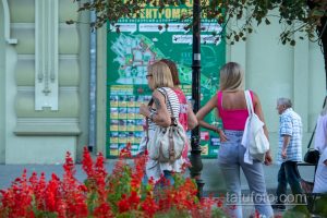 Фото тату на плече женщины, изображающее темный рисунок на фоне городской карты. Татуировка выглядит стильно и привлекательно.
