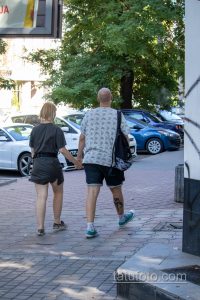 Фото мужчины с татуировкой на ноге, идущего по улице. Татуировка выполнена в темных тонах и видна из-под шорт.