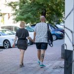 Фото мужчины с татуировкой на ноге, идущего по улице. Татуировка выполнена в темных тонах и видна из-под шорт.