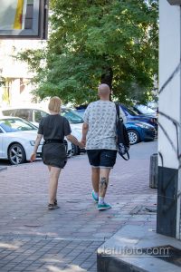 Фото мужчины с татуировкой на ноге, идущего по улице. Татуировка выполнена в темных тонах и видна из-под шорт.