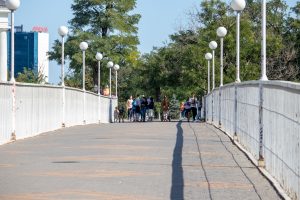 Вид на Одесскую набережную с моста. Прохожие, фонари и архитектура создают атмосферу морского города.