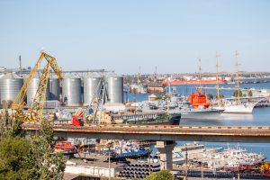 Панорамный вид на Одесский порт с моста. Корабли, краны, склады и море создают индустриальный пейзаж.