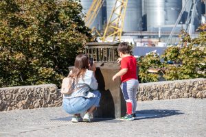 Фотография матери и сына, фотографирующих что-то на улице. У матери видна татуировка на плече.