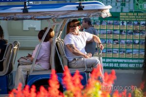 Фото татуировки на руке мужчины в туристическом автобусе. Темный узор, вероятно, геометрический или абстрактный, расположен на предплечье.