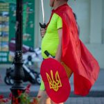 Фото мужчины в костюме героя с плащом и мечем – щитом с украинским гербом – Уличная татуировка 14.09.2020 – tatufoto.com 1